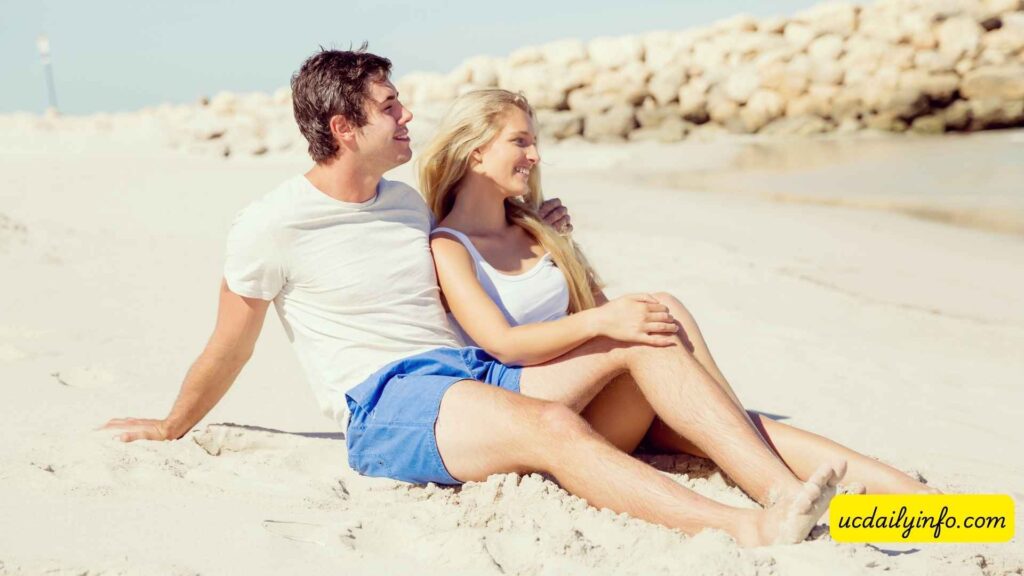 Couple-sitting-together-on-the-sand-beside-the-ocean-25-Romantic-Couple-Vacation-Ideas