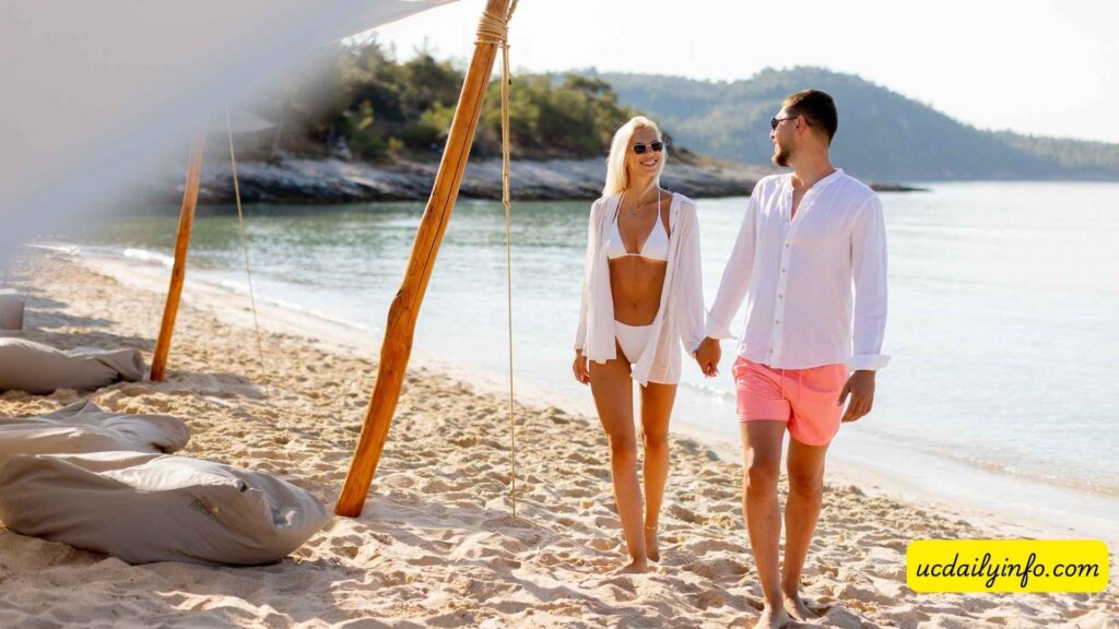 Romantic-couple-walking-hand-in-hand-along-a-beach-at-sunset