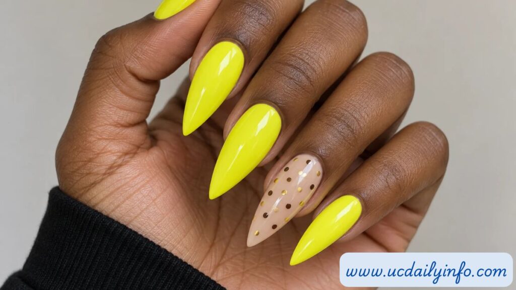 Neon yellow stiletto nails with a dotted beige accent nail